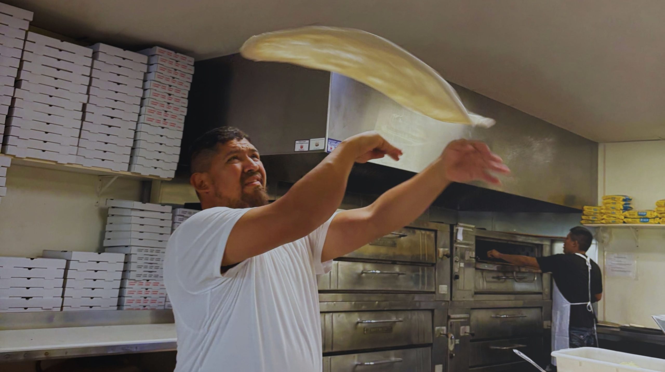 Pizza maker tossing dough in the DeVino's kitchen